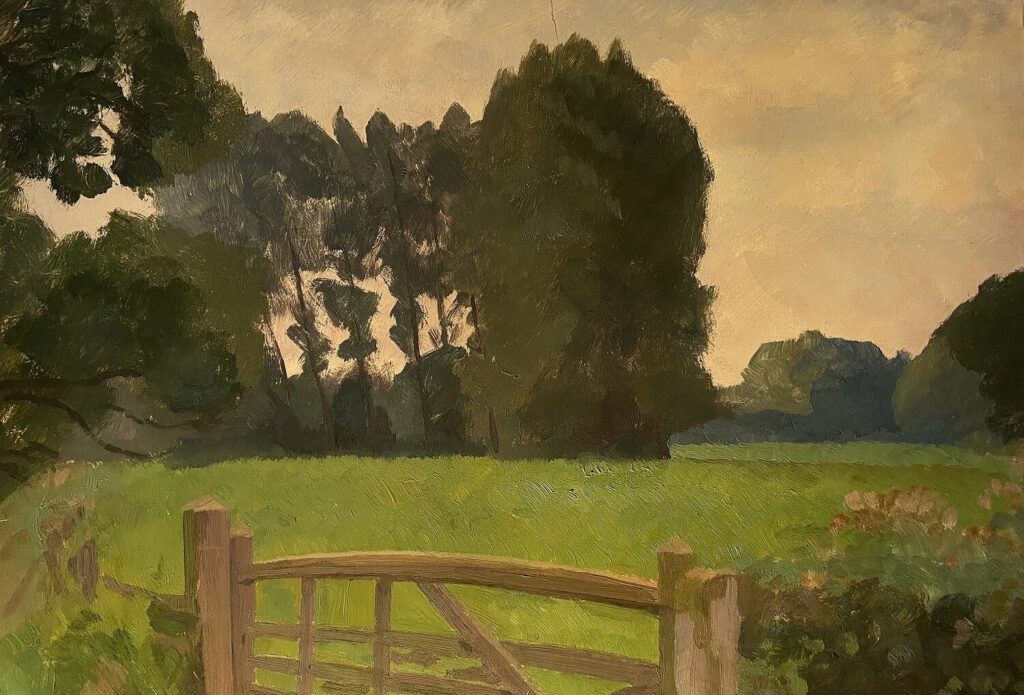 View over a bow toped wooden gate, with a meadow beyond